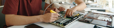 Colleagues Repairing Computer In Team