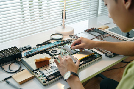 Repairman Repairing Laptop In Workshop