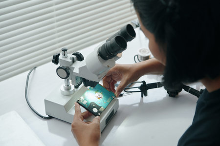 Master Examining Disk Under Microscope