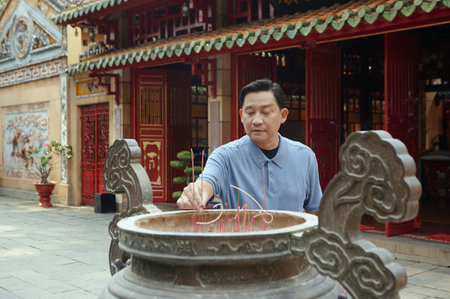 Man Putting Aroma Sticks In Cupの写真素材