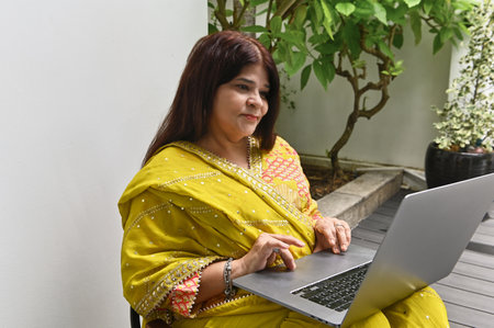 Indian Woman Using Laptop Outdoorsの写真素材