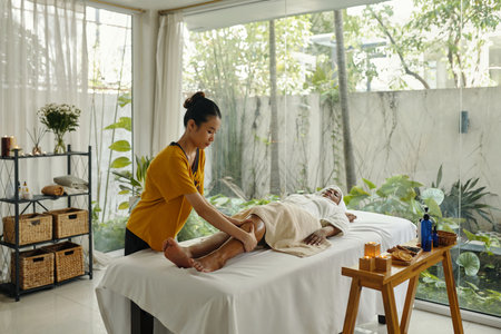 Performing Relaxing Leg Massage in Serene Roomの写真素材