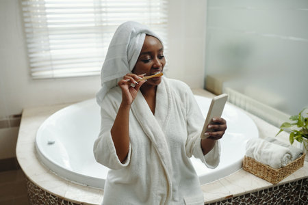 Brushing Teeth While using Smartphone in Bathroomの写真素材