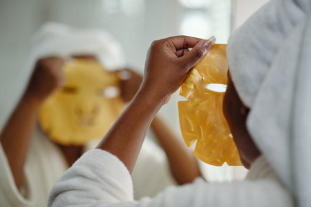 Applying Skin Care Mask While Wearing White Bathrobeの写真素材