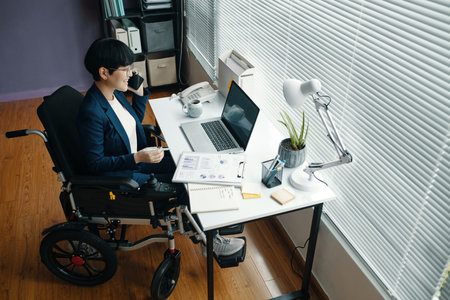 Businesswoman Discussing Financial Charts By The Phoneの写真素材