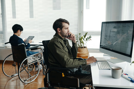 Colleagues With Disability Working In Officeの写真素材