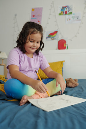 Girl Drawing Picture In Her Roomの写真素材