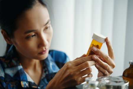 Asian Girl Looking At Jar Of Pillsの写真素材