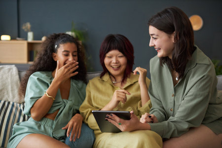 Three Girls Enjoying Watching Funny Videos In Internetの写真素材