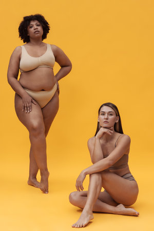 Diverse Women Posing Against Bright Yellow Backgroundの写真素材