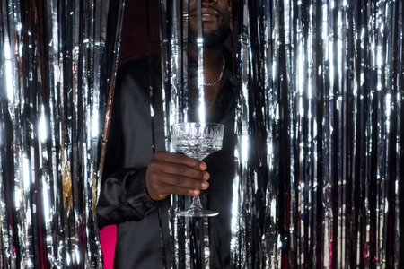 Holding Glass Behind Sparkly Party Curtainの写真素材