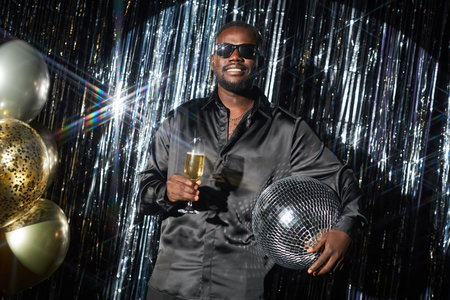 Holding Champagne Glass and Disco Ball at Party