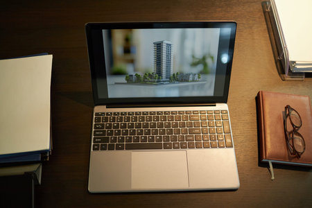 Laptop with Picture of Building on Screen on Wooden Table
