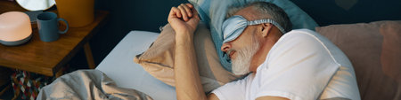 Senior man peacefully sleeping on bed, wearing an eye mask for better rest, with bedside table...