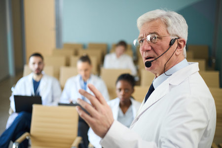 Portrait of senior doctor giving presentation to medical staff in conference room, with colleagues...