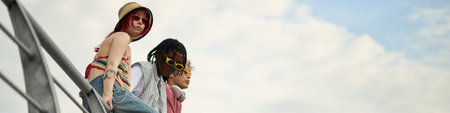 Header of three teenagers, including Caucasian girl and Black boy, sitting on outdoor structure,...