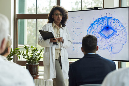 Young Black woman presenting neuroscience research to diverse group, standing in front of digital...