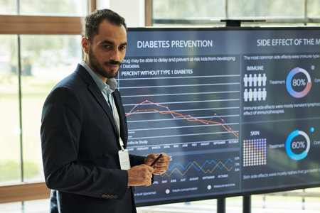 Young polyethnic male healthcare professional presenting diabetes prevention data on digital screen,...