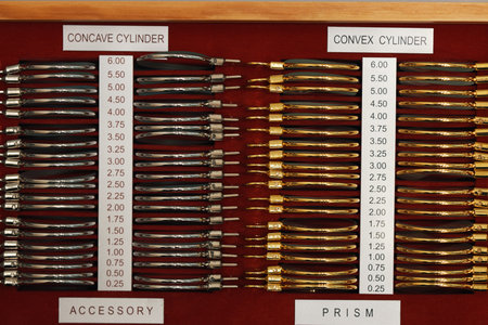 Optometry trial lens set displaying organized rows of concave and convex cylinder lenses with...