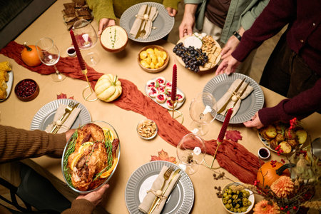 Diverse group of young adult and middle aged men and women serving traditional Thanksgiving dinner,...