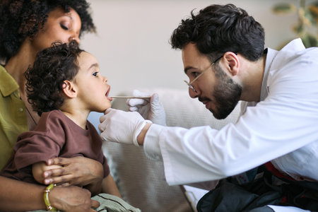 Black mother holding toddler while male doctor examining throat with swab during home visit