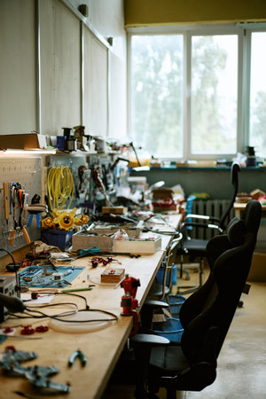 Vertical image of electronics workshop workbench with tools, soldering equipment, hardware components for engineering projects, hardware prototyping, robotics development