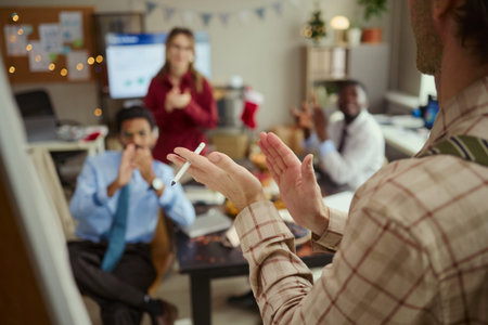 Caucasian young adult man presenting project near whiteboard to diverse multiethnic team applauding in office. Image suitable for corporate communication and teamwork marketing