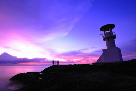 Lighthouse searchlight beam through marine air at nightの写真素材