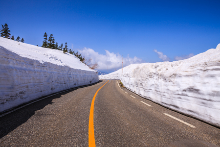 TATEYAMA, JAPAN - Apr 15, 2016: Unidentified tourists walk along snow corridor on Tateyama Kurobe Alpine Route, Japanese Alp in Tateyama, Japanのeditorial素材