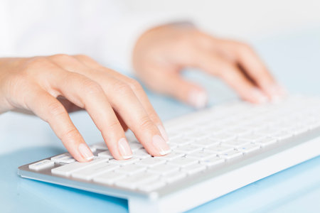 Close-up of business woman's hands touching computer keys during work