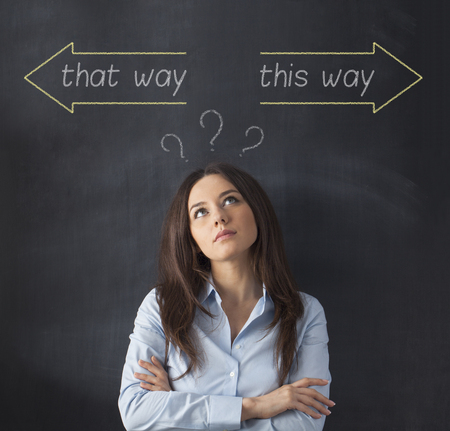 Businesswoman making decision on blackboardの写真素材