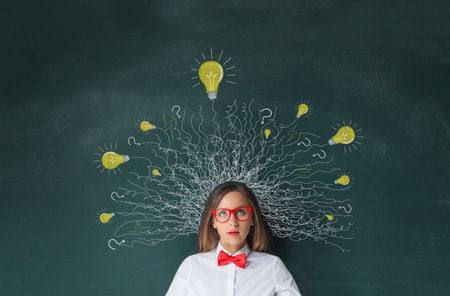 Thinking woman with lightbulbs drawing above head on blackboard backgroundの写真素材