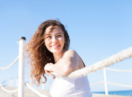 Happy young woman posing over blue skyの写真素材