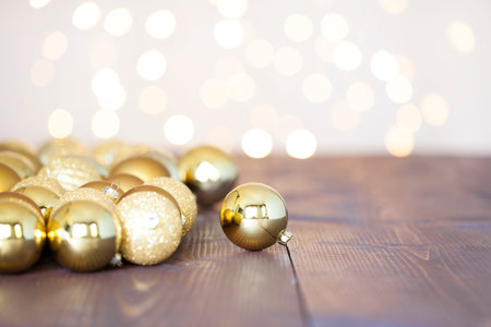 Christmas baubles with christmas tree lights on wooden background