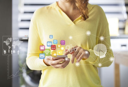 Hand holding smartphone with colorful app icons conceptの写真素材