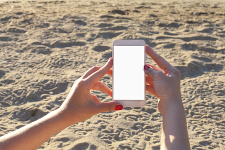 Woman using her mobile phone on the beachの写真素材