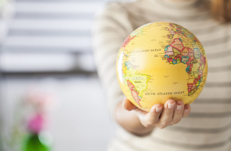 Woman hand holding an earth toy globeの写真素材
