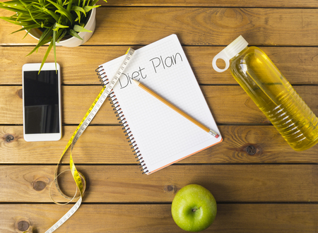 Notebook with words diet plan on a wood board. Weight lose concept.の写真素材