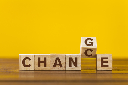 Wooden cube with word "Change & Chance" concept on yellow backgroundの写真素材