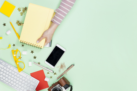 Woman holding a empty notebook on table top view. Female blogger working deskの写真素材