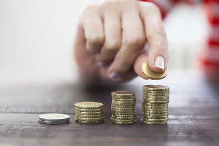 Female hand stack coins to shown concept of growing business and wealthy. Saving money conceptの写真素材
