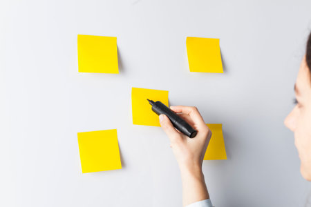 Businesswoman putting her ideas in sticky-note planning on business strategy