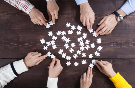 Business people finding solution together at office. Jigsaw puzzle and searching solutions concept.