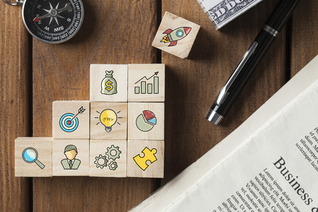 Startup concepts with business strategy symbols on wooden cubes. Flat lay.の写真素材
