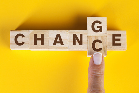 Woman finger pushing wooden cube with word change to chance lettersの写真素材