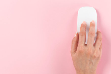 Person using computer mouse on pink background