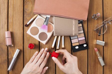 Female hands doing nail polish on dressing tableの写真素材