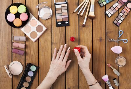 Female hands doing nail polish on dressing tableの写真素材