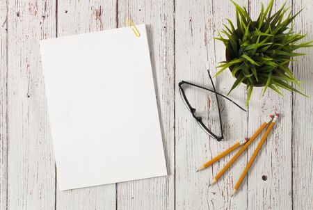 Blank paper sheets for brochure and pencils on wooden background, flat lay. Mock upの写真素材