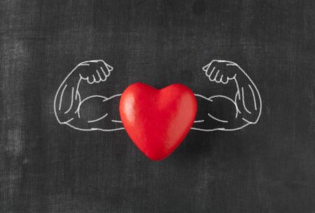 Heart with muscular arms drawn on blackboardの写真素材